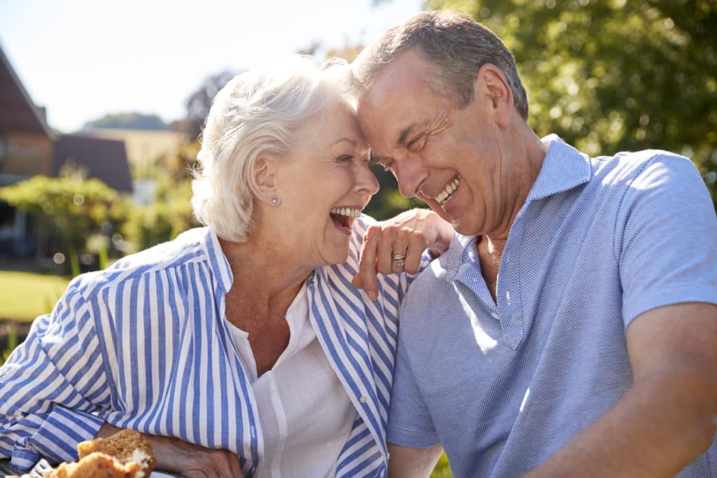 Senior Couple Enjoying Outdoor Summer Snack At Cafe