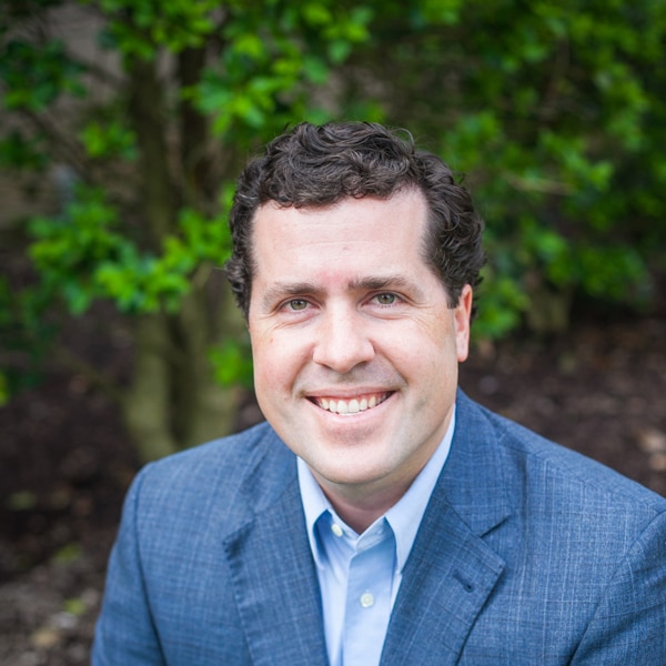 Photo of a man in a blue suit smiling