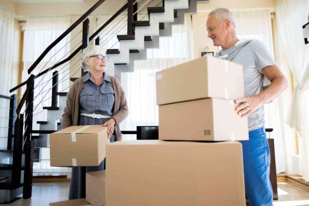 Man and woman stacking packed brown boxes