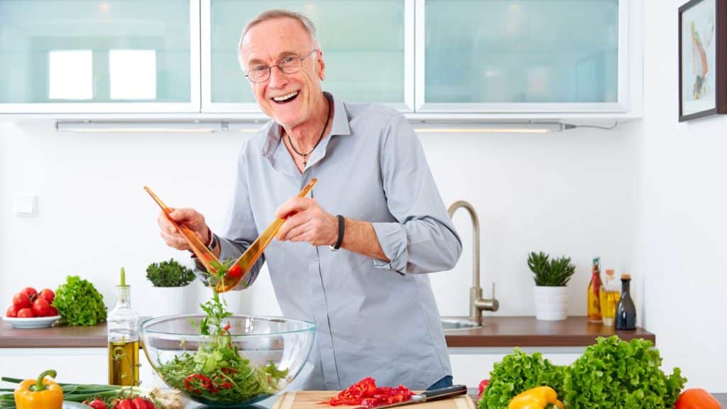 Man in the kitchen preparing a salad