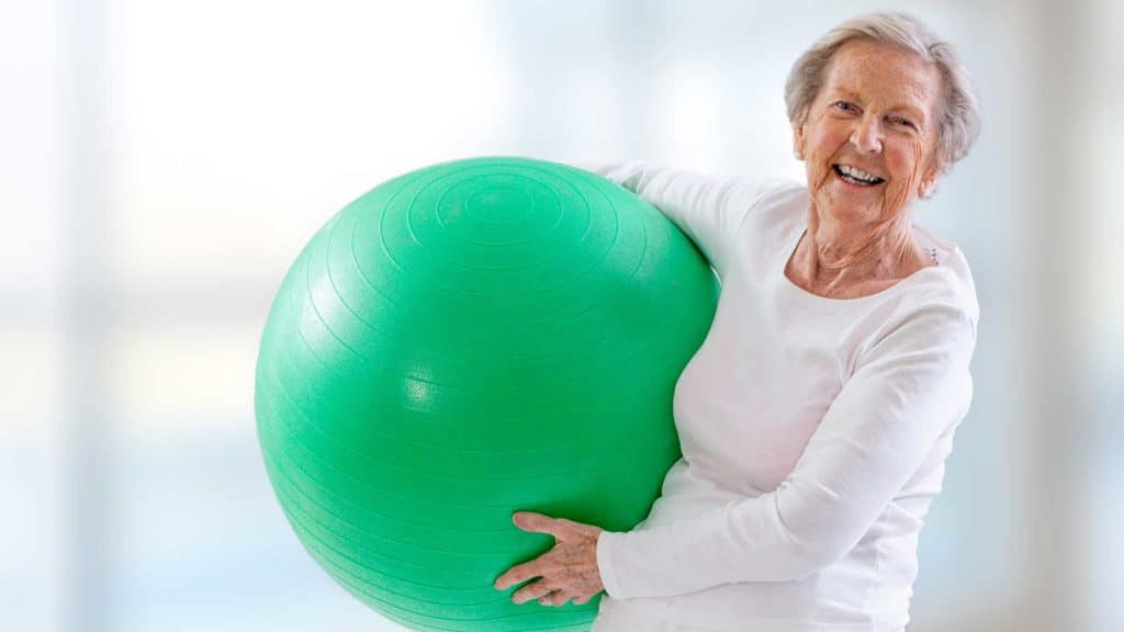 Woman holding a green yoga ball