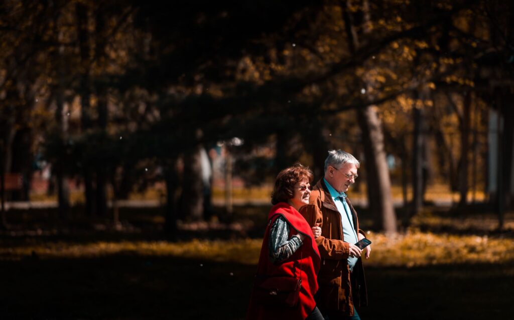 Autumn like photo of man & woman walking in the park