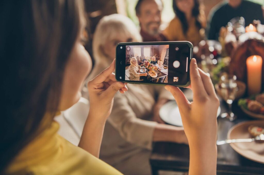 Woman holding a cell phone taking a picture of a group