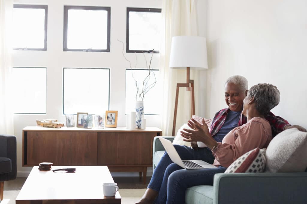 Man & woman sitting in front of computer smiling