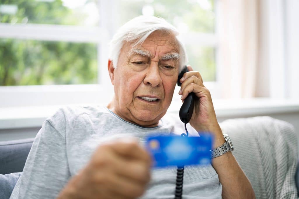 Man on the phone looking at a card