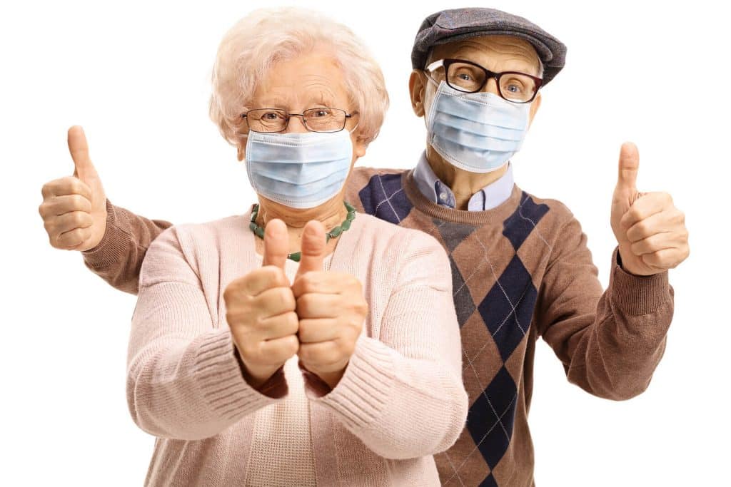 Man & woman with mask on giving thumbs up