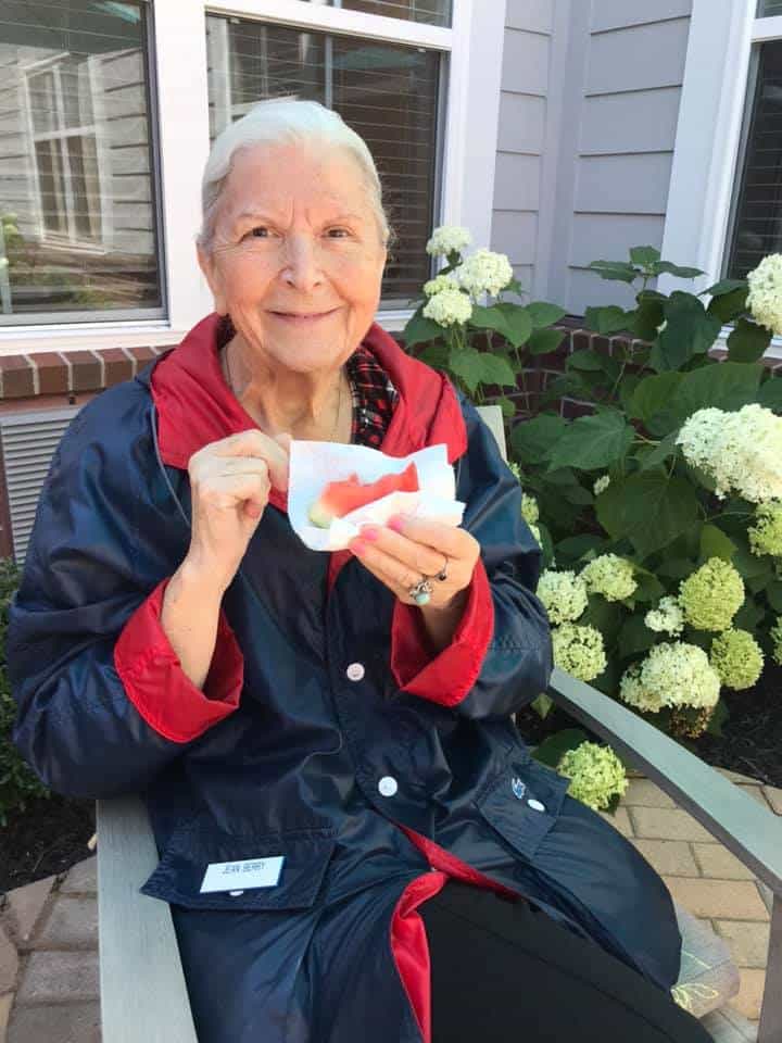 Resident enjoying a slice of watermelon at Traditions of Mill Creek