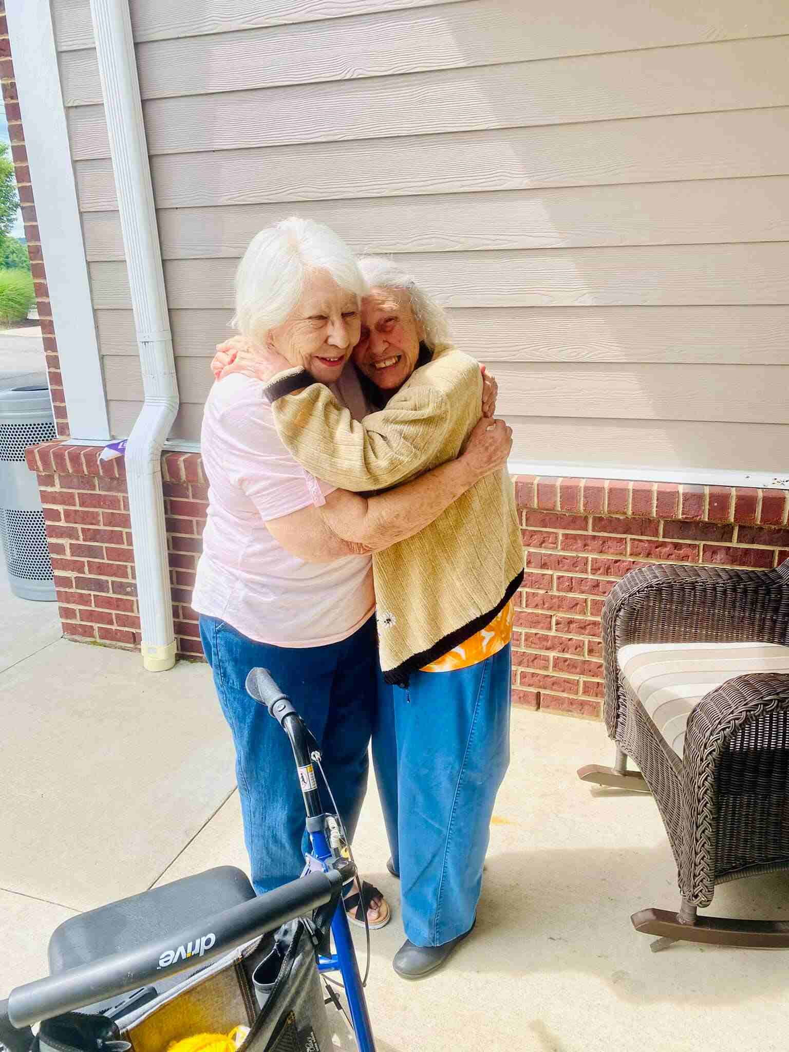 Two women hugging and smiling outside at Traditions of Spring Hill