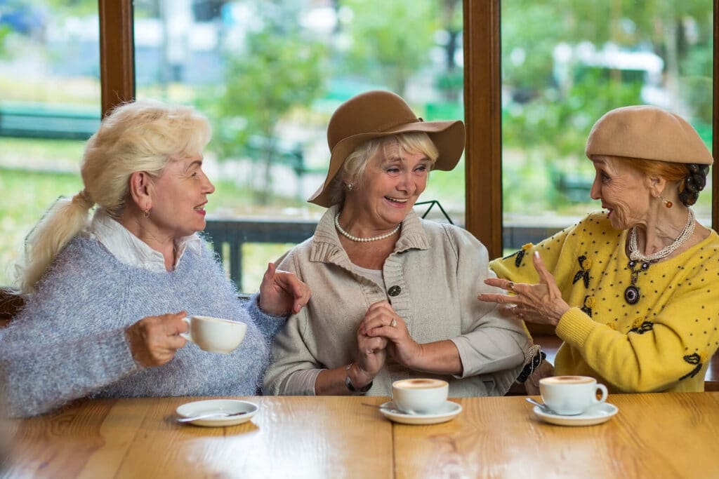 Three women sitting a table drinking lattes