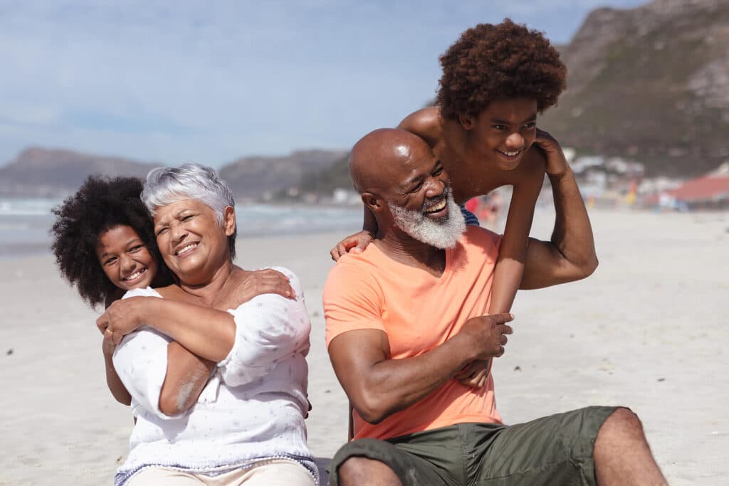 Man & woman enjoying the day on the beach with two younger children