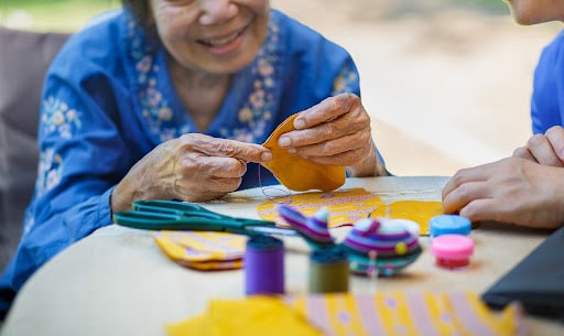 Woman sitting at a table doing arts & craft