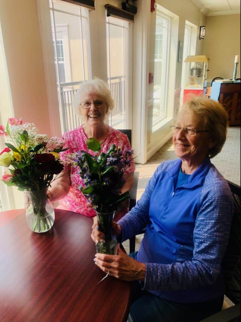 Women sitting and laughing with two bouquets of flowers