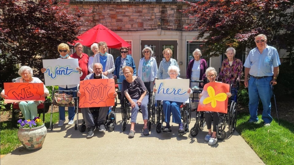 Group of Maristone residents holding welcome signs at Providence entrance
