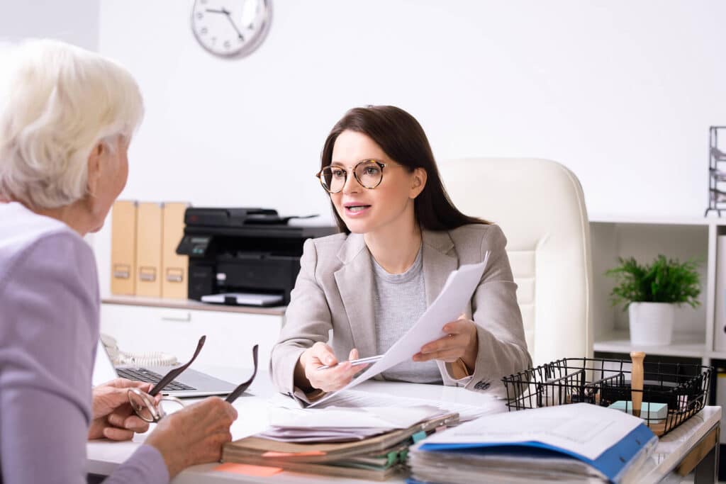 Two women at a desk reviewing paperwork