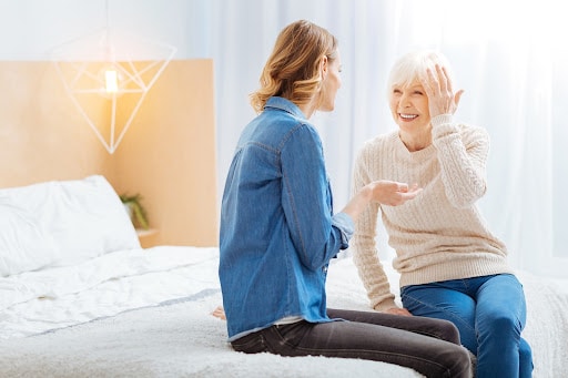 Two women sitting on the bed talking