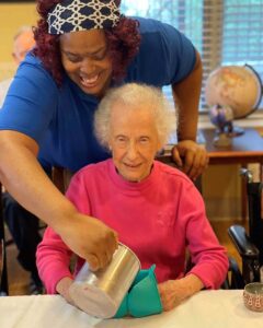 Photo of an aid helping a resident with a craft