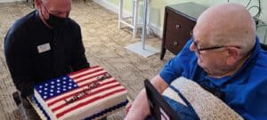 Vitality staff presenting an American flag cake to a resident