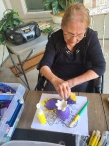 Photo of woman sitting at table doing arts and crafts