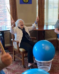 Senior woman playing drums and laughing