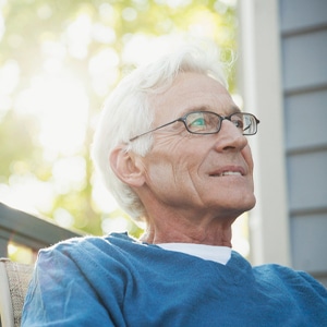 Photo of a man with grey hair and glasses smiling
