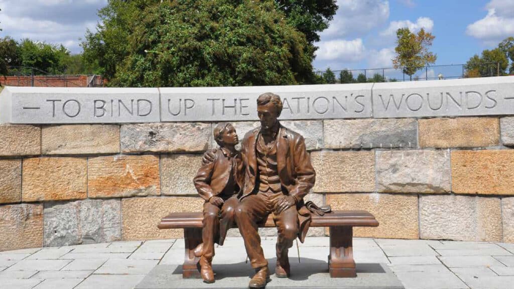 Brass statue of Abe Lincoln with child on bench