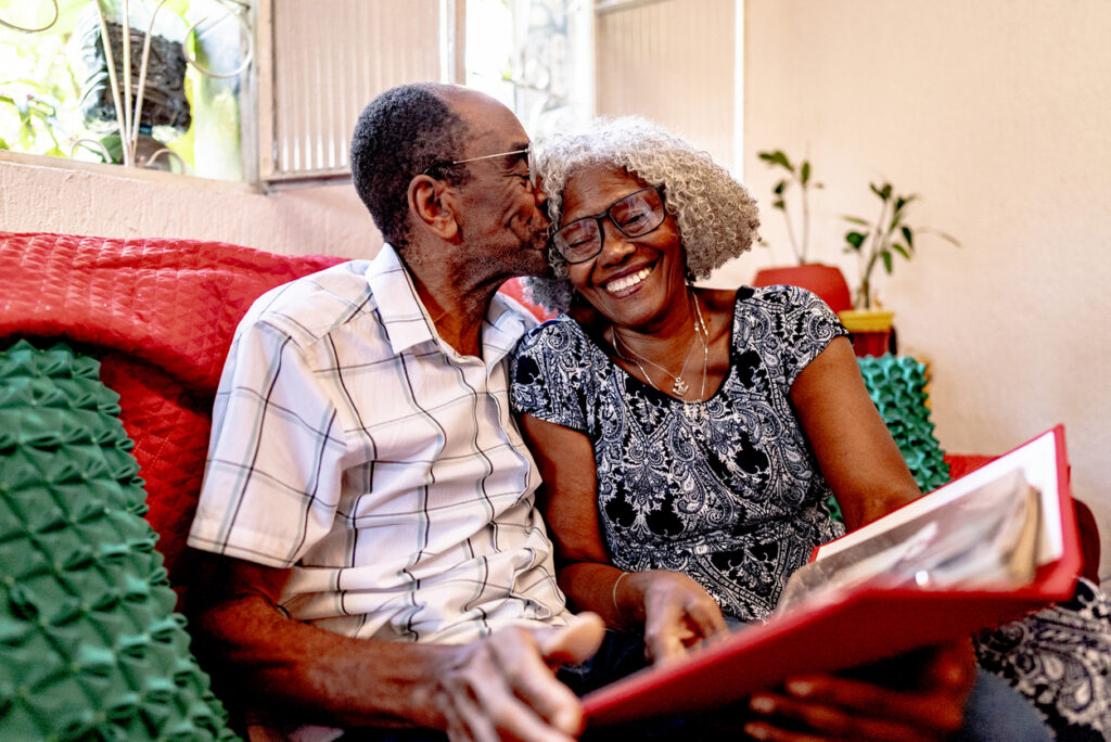 Senior couple talking and looking at a photo album amidst a dementia diagnosis