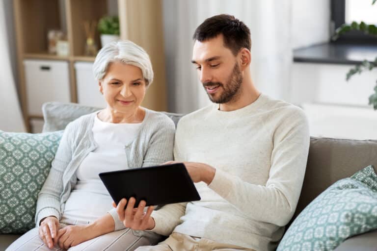 family, technology and people concept - adult son teaching his s