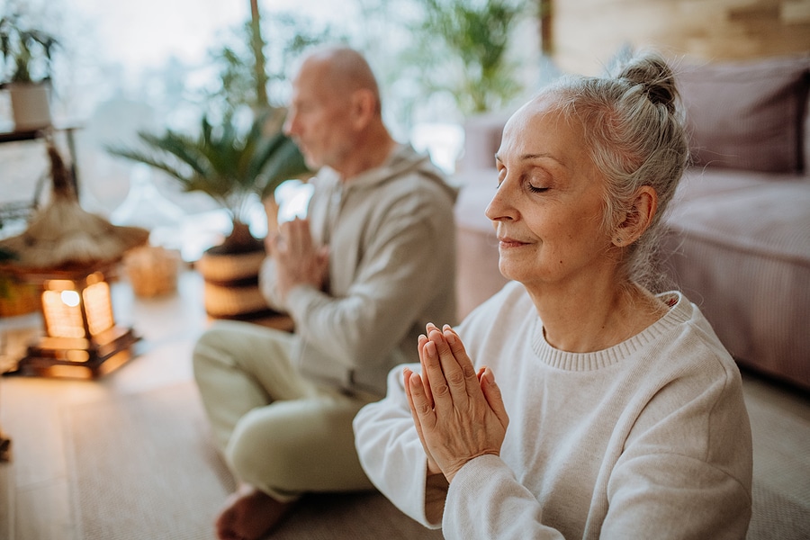 Senior couple staying active in the winter by practicing yoga and meditation