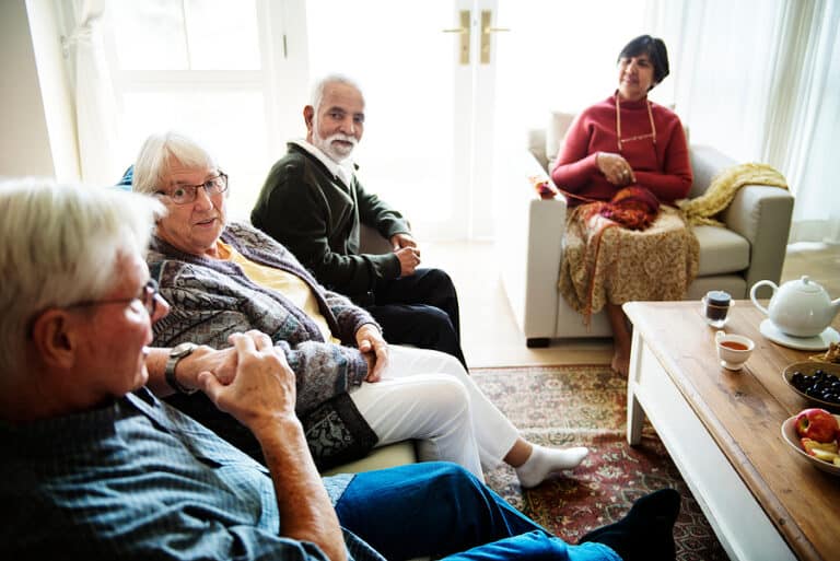 A group of seniors gathered and talking in a senior living community