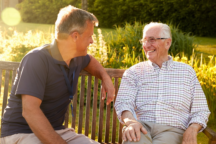A son and his father are outside having a conversation about assisted living and next steps