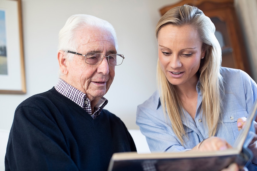 Father and daughter looking at an old photo book together