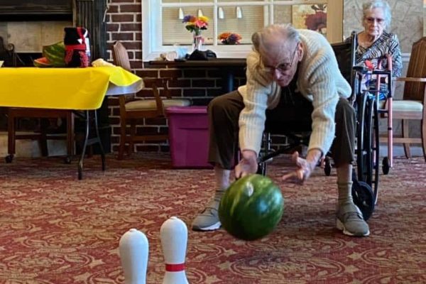 senior man bowling with a watermelon