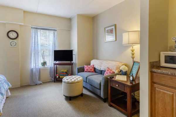 Model bedroom with bed, TV and couch